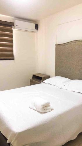 a white bed with a white towel on top of it at Casa 5 Centrica Super ubicada 3 camas queen in Hermosillo