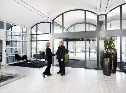 two people shaking hands in an office lobby at Comwell Kolding in Kolding
