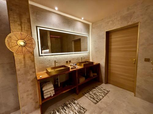 a bathroom with two sinks and a mirror at ExSPArience Private Spa Suite in Poitiers
