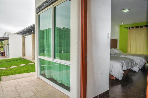 a bedroom with a bed and a large sliding glass door at Hotel Real Tamasopo in Tamasopo
