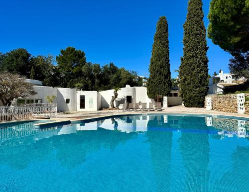 a swimming pool with trees in front of a house at Casa Luca in Carvoeiro