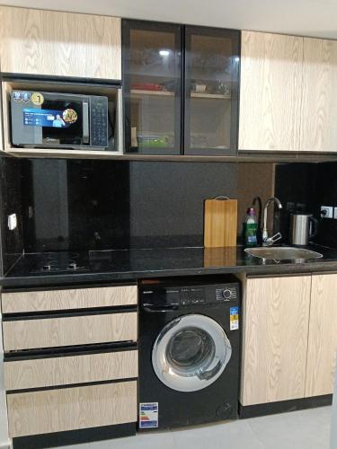 a kitchen with a washing machine and a microwave at scandic resort sea view balcony free wi fi in Hurghada