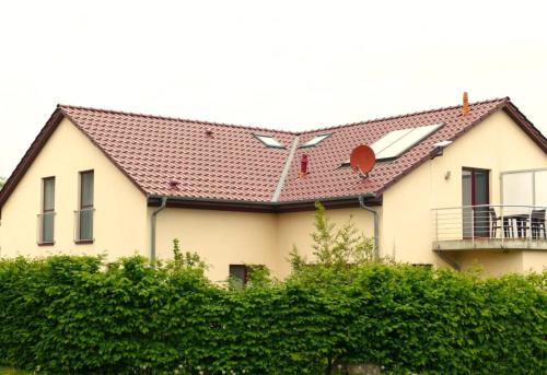 a white house with a red roof at Casa Cavallo in Göhren-Lebbin