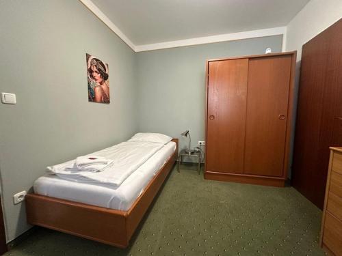a small bedroom with a bed and a wooden door at Mariazellerhof Room 014 in Sankt Pölten