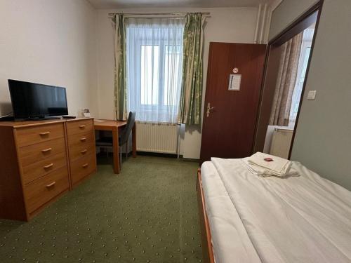 a hotel room with a bed and a desk and a television at Mariazellerhof Room 014 in Sankt Pölten