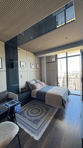 a bedroom with a large bed and a balcony at Premium Smart Studio with River View in Tbilisi City