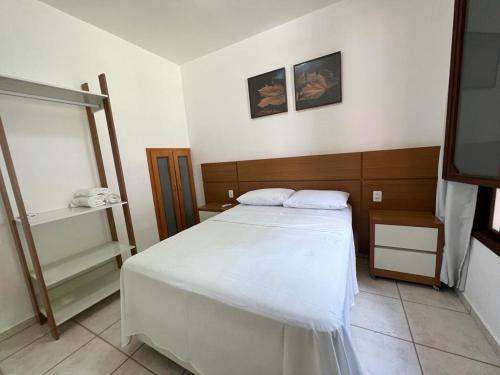 a bedroom with a white bed and a television at Casa - Conceito in Bom Jesus da Lapa
