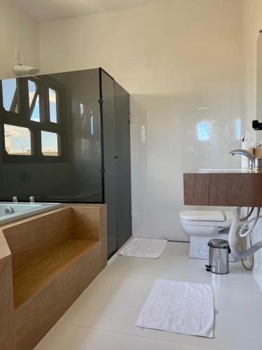 a bathroom with a tub and a toilet and a sink at Casa - Conceito in Bom Jesus da Lapa
