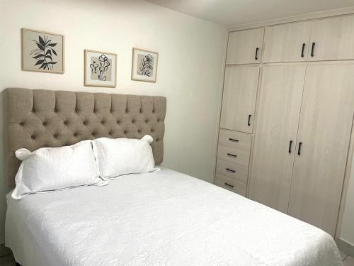 a bedroom with a large white bed and a cabinet at Casa 11 Centrica 3 camas queen in Hermosillo