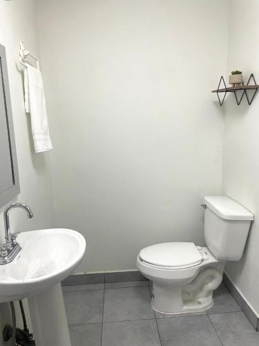 a white bathroom with a toilet and a sink at Casa 11 Centrica 3 camas queen in Hermosillo