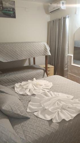 a white dress laying on a bed in a bedroom at Hotel Antonia in Termas de Río Hondo