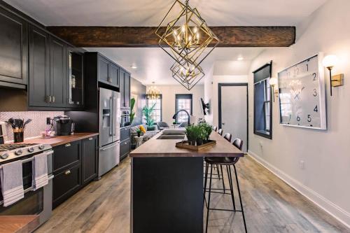 a kitchen with black cabinets and a chandelier at King Bed / Free Parking / BBQ / Fire pit / Arcade in Pittsburgh