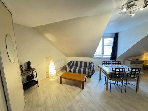 Appartement centre Compiègne في كومبيان: غرفة معيشة بها أريكة وطاولة