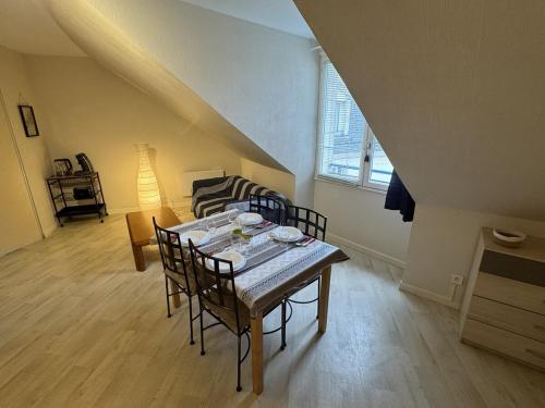 a living room with a table with chairs and a couch at Appartement centre Compiègne in Compiègne