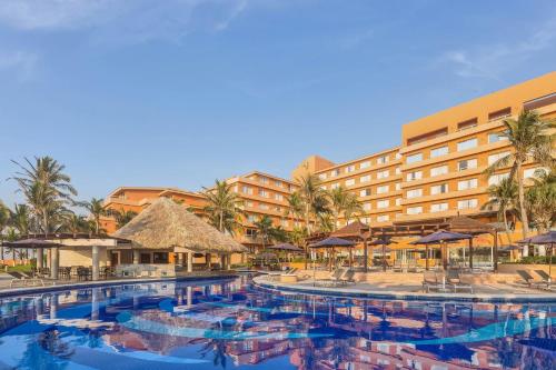 a resort with a large pool with chairs and umbrellas at Grand Fiesta Americana Veracruz in Veracruz