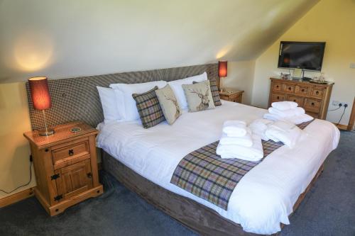 a bedroom with a large bed with towels on it at Corncrake Cottage in Leverburgh