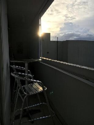 a window on a building with the sun shining through at Saint Tropez in San Juan