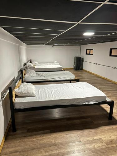 two beds in a large room with at Asha Hostel in Fortuna