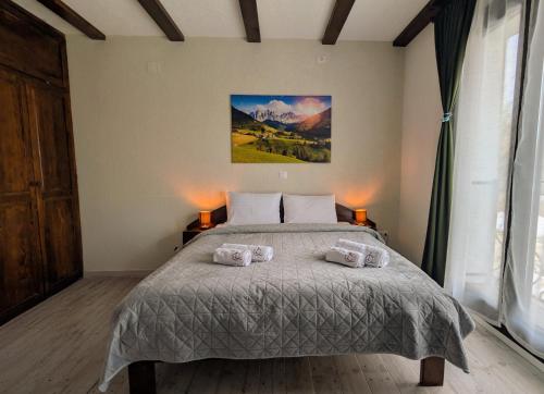 a bedroom with a bed with two pillows on it at Conacu Lacului Brebu in Brebu Mînăstirei