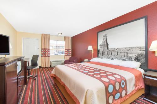 a hotel room with a large bed and a desk at Super 8 by Wyndham Temple S General Bruce in Temple