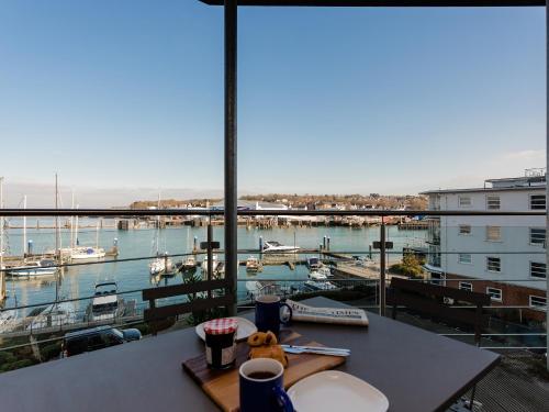 a room with a table with a view of a marina at 16 Marinus in Cowes