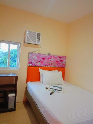 a bedroom with a bed with a flower headboard at Rafael Suites Inn in Mojon