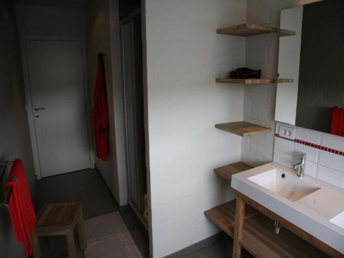 a bathroom with a white sink and a red towel at Countryside holiday home in Gijverinkhove