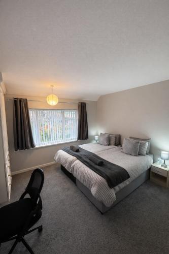 a bedroom with a bed and a chair and a window at Charming 3 BR - NEC HS2- Long Stays Wifi Parking Airport in Shirley