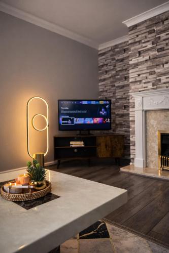 a living room with a tv and a fireplace at Charming 3 BR - NEC HS2- Long Stays Wifi Parking Airport in Shirley