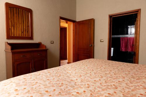 a bedroom with a bed and a dresser and a door at Cabañas Sierra Verde in Cedro