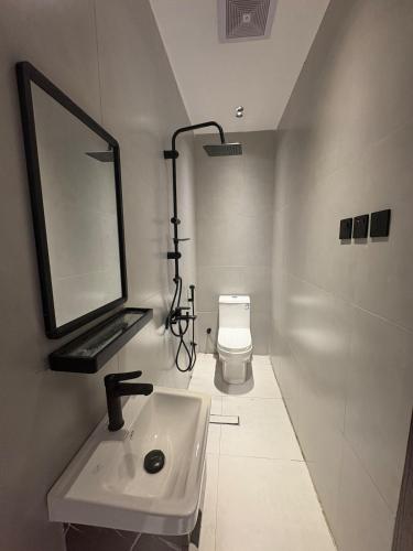 a bathroom with a sink and a mirror and a toilet at فنادق مخدومة in Quai