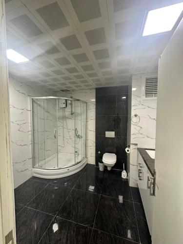 a bathroom with a glass shower and a toilet at Nera Otel in Istanbul
