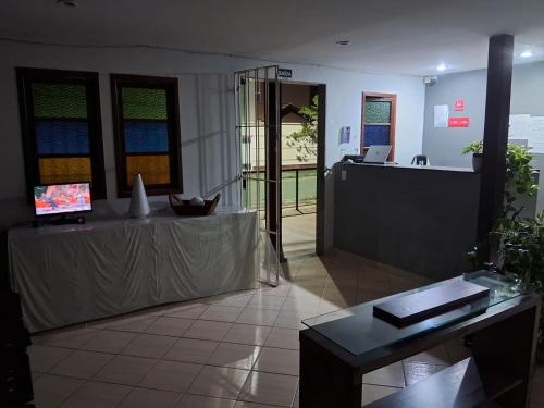 an office with a table and a desk in a room at Pousada Paraiso - Predio N 124 in Guarapari