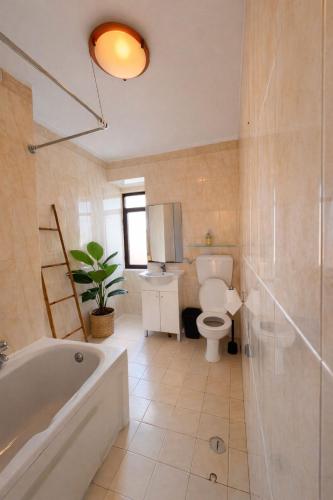 a bathroom with a tub and a toilet and a sink at Sintra Central Apartment in Sintra