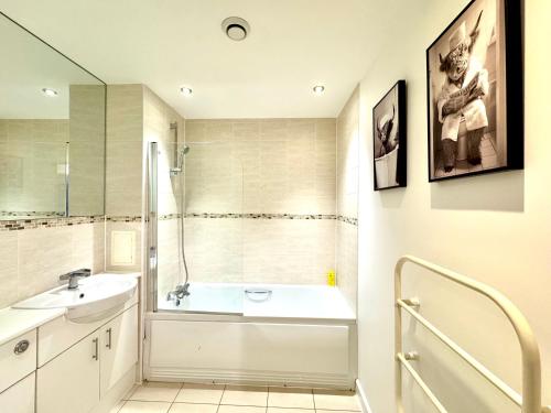a bathroom with a tub and a sink and a shower at VIPAbodes at The Nankeville Woking in Woking