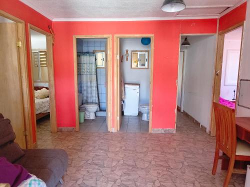 a room with two toilets and a red wall at Casona Mamalluca in El Durazno