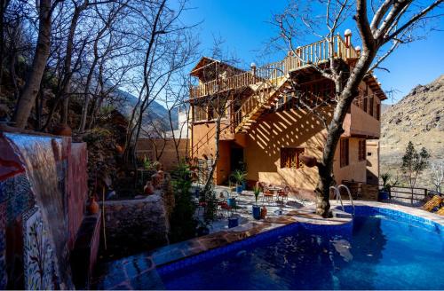 a house with a swimming pool in front of a house at Riad Atlas Bangalow in Imlil