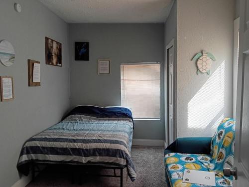 a bedroom with a bed and a chair at The Jax Hideout in Jacksonville