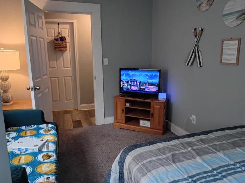 a bedroom with a bed and a television on a cabinet at The Jax Hideout in Jacksonville