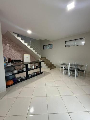 a kitchen with a table and chairs and a staircase at Casa Guriri in São Mateus