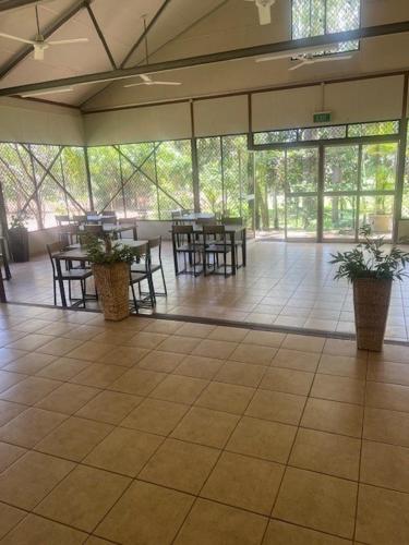 a large room with tables and chairs and plants at Pandanus on Litchfield in Batchelor