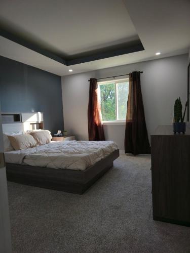 a bedroom with a large bed and a window at The Lots home in Winnipeg