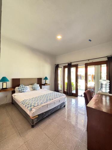 a bedroom with a large bed and some windows at Tropical Beach Resort Sekongkang in Sekongkang Bawa