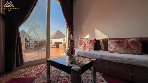 a living room with a couch and a large window at Golden Pyramids Inn in Cairo