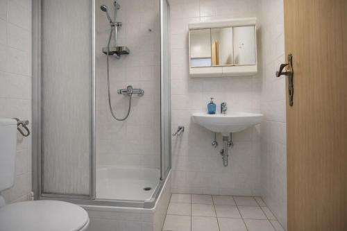a bathroom with a shower and a sink and a toilet at Haus Wilbrand Ferienzimmer 1 in Warnemünde