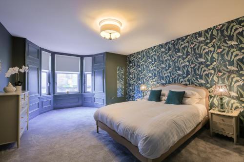a bedroom with a large bed with a green wall at Gordon's Getaway Lux in Oban