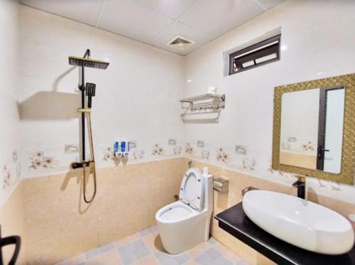 a bathroom with a sink and a toilet and a mirror at Tuấn Đạt Luxury FLC Sầm Sơn in Sầm Sơn