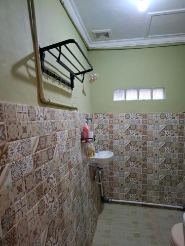a bathroom with a sink and a mirror in it at ParabonHaus Kopitiam - Bed & Breakfast in Gegarbensang