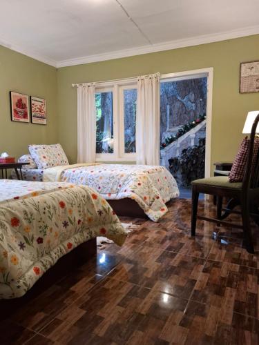 a bedroom with two beds and a window at ParabonHaus Kopitiam - Bed & Breakfast in Gegarbensang