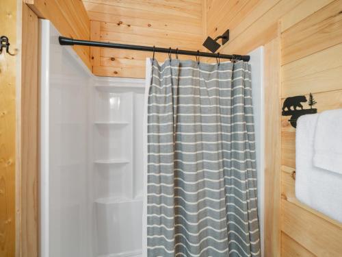 a bathroom with a shower curtain in a cabin at The Three Dog Night Cabin in Bryson City